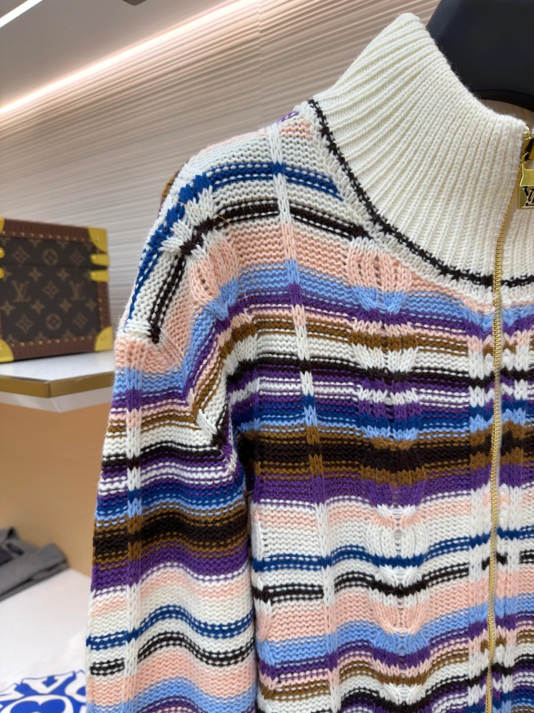 LOUIS VUITTON letter badge color block cable zipper knitted jacket ●Original version: purchased and developed by 21570 ●Item number: 1682322-C15 ●Fabric: wool blended fabric ●Technology: knitting ●Color: pattern ●Version: fitted version ●Weight: about 710 grams ●Size: S-M-L-XL ●Description: This Louis Vuitton color-blocked striped knitted cardigan is made of merino wool and cashmere blended yarn and is woven on a 12-needle coarse-gauge computerized flat knitting machine. The body is interlaced with cable knitting and plain knitting. The stripes are directly knitted with colored yarns instead of post-printing and dyeing. The ratio of colored yarns for each stripe is accurately calculated, making the color transition natural and not easy to fade. The placket is equipped with a customized brass zipper, and the zipper teeth are polished and gold-plated, which is both smooth and durable. The leather label on the left chest is fixed with first-layer calfskin through heat embossing process, and the edges are hand-polished without burrs. The neckline is designed with a high-elastic ribbed stand-up collar, which is not easily deformed after being shaped at high temperatures. The ribbed edges on the cuffs and hem are woven with double-strand yarn, which is more elastic. The shoulders are seamlessly woven with raglan sleeves to reduce the feeling of seams rubbing against the skin. The overall loose fit is combined with three-dimensional tailoring, which not only retains the soft texture of knitting, but also creates a crisp silhouette. Each piece is hand-ironed and quality-checked by brand craftsmen. The overall wiring is straight and delicate, the fabric is comfortable and soft, and the color is consistent without color difference. It can be matched with the same style to create a fashionable look and control various occasions. Customized accessories, complete with three standards, same style for men and women!